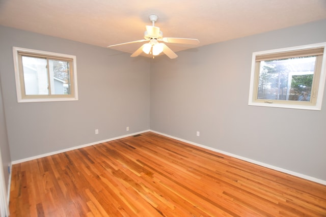 unfurnished room with hardwood / wood-style floors, a wealth of natural light, and ceiling fan