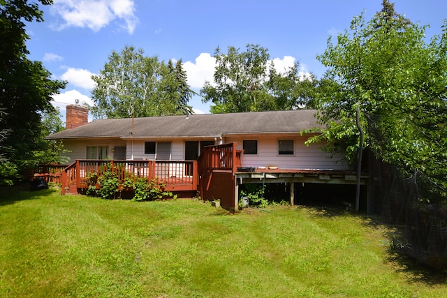 rear view of property featuring a yard and a wooden deck