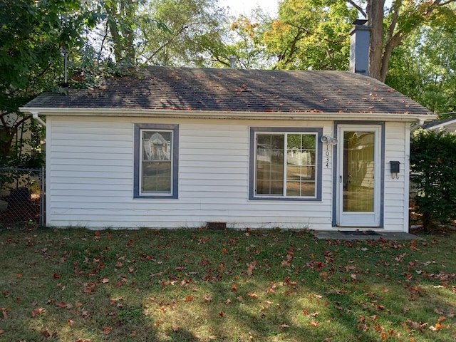 rear view of house featuring a lawn