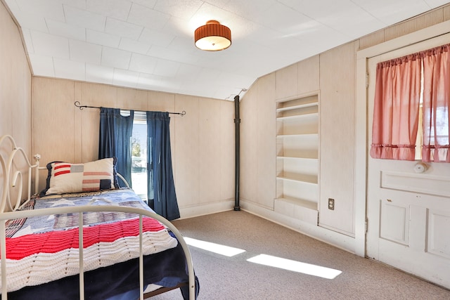 carpeted bedroom with wooden walls