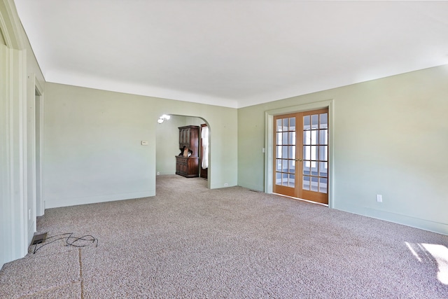 carpeted empty room featuring french doors