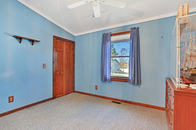 unfurnished bedroom featuring ceiling fan, a closet, light colored carpet, and vaulted ceiling