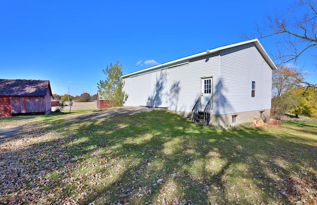 back of property with an outbuilding and a yard