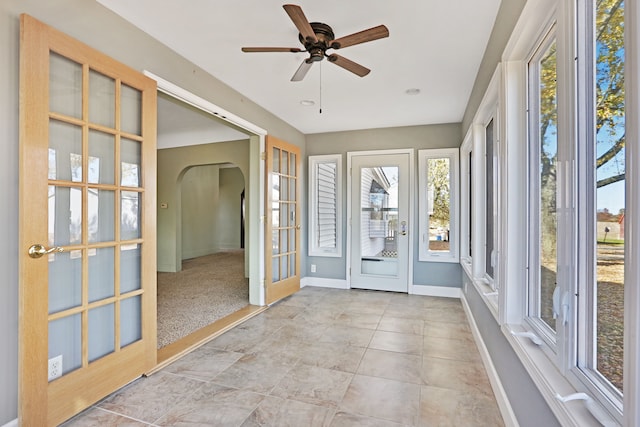 unfurnished sunroom featuring french doors and ceiling fan