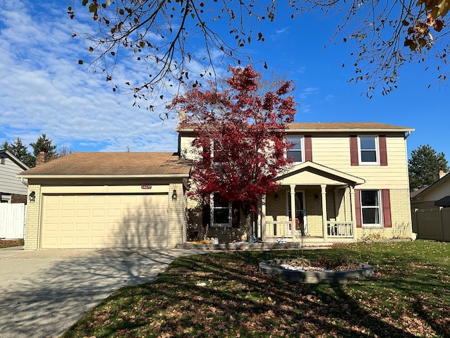 view of front of property with covered porch, a garage, and a front lawn