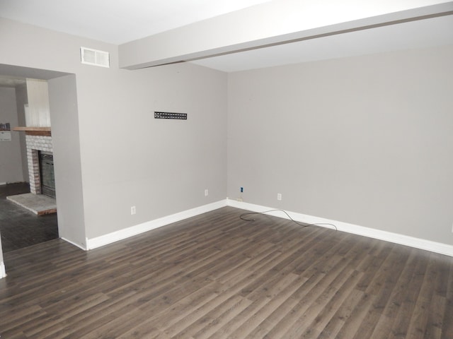 unfurnished room with a fireplace and dark wood-type flooring