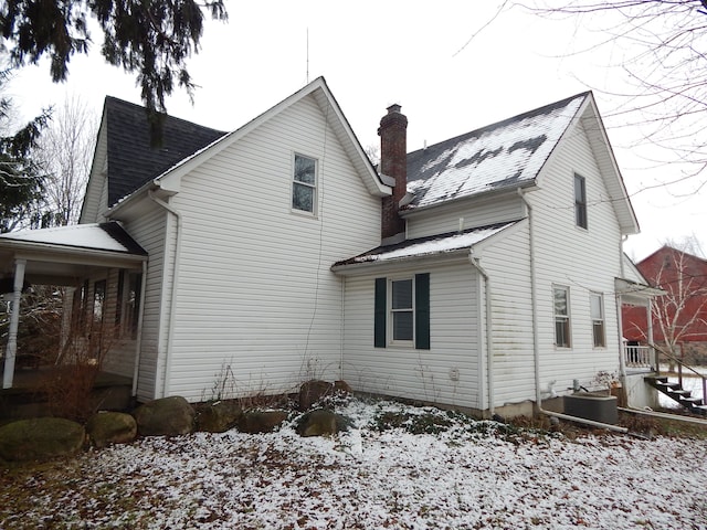 view of snowy exterior featuring cooling unit