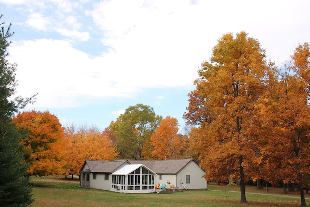 view of front of property with a front yard and a sunroom