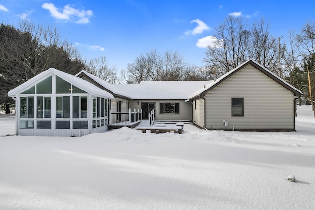 snow covered property featuring a sunroom