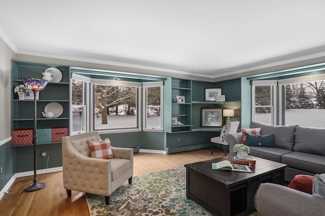 living room with light hardwood / wood-style floors, baseboard heating, and crown molding