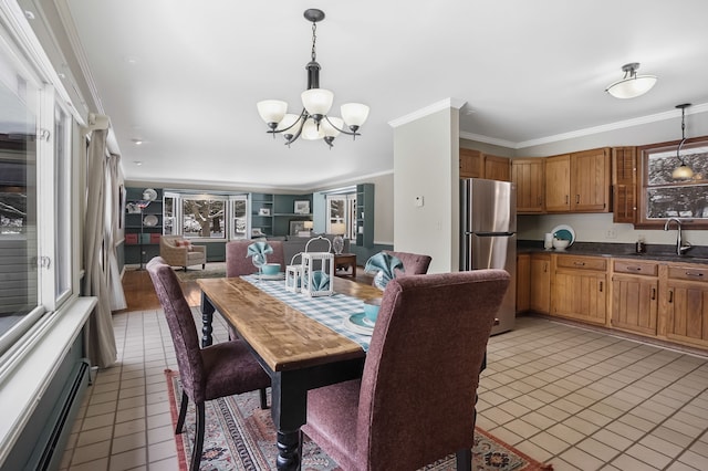 tiled dining room featuring baseboard heating, sink, crown molding, and a chandelier