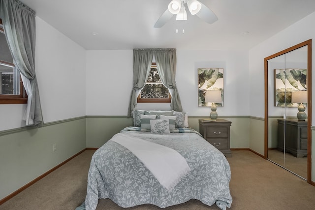 carpeted bedroom with ceiling fan and a closet