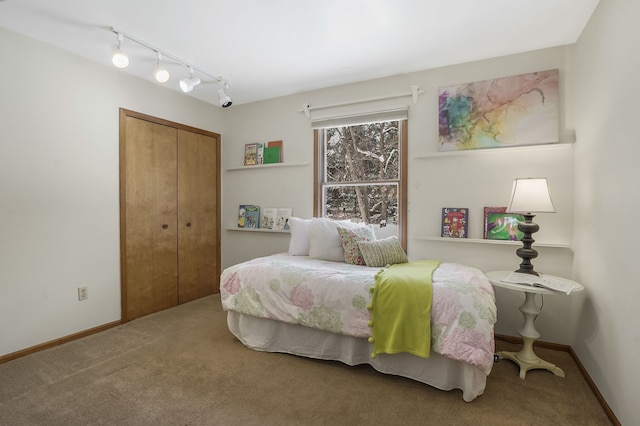 carpeted bedroom featuring a closet and rail lighting