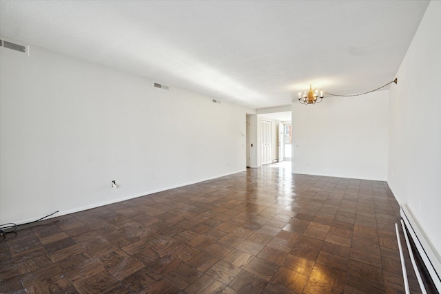 spare room with a notable chandelier, dark parquet floors, and a baseboard radiator