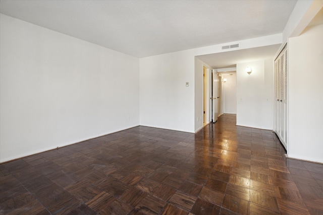 spare room with dark parquet flooring