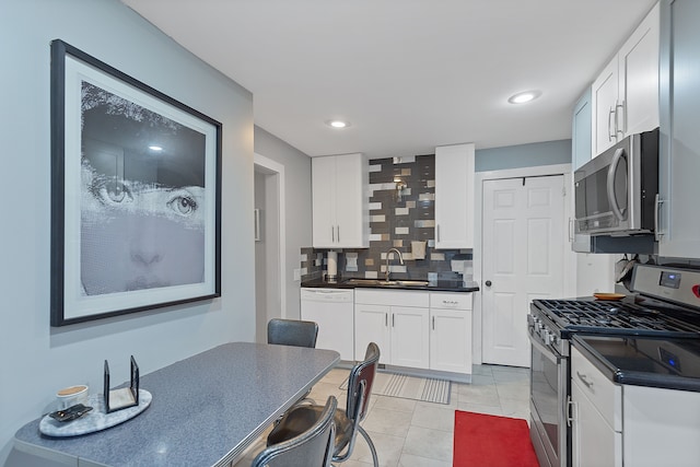 kitchen with white cabinets, appliances with stainless steel finishes, backsplash, and sink