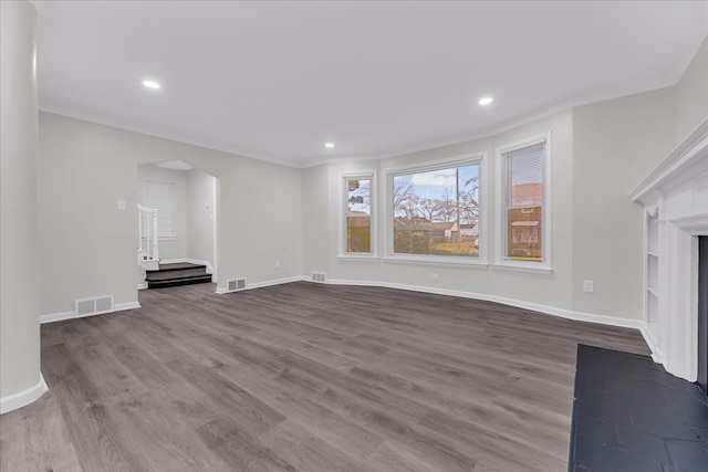 unfurnished living room featuring hardwood / wood-style flooring and built in shelves