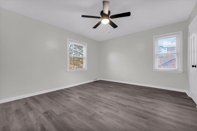 empty room with dark hardwood / wood-style floors and ceiling fan