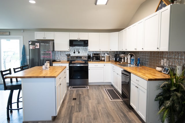 kitchen with black appliances, white cabinetry, butcher block counters, and sink