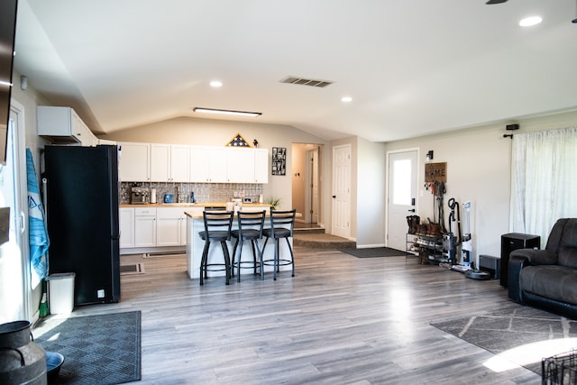 living room with hardwood / wood-style floors and vaulted ceiling