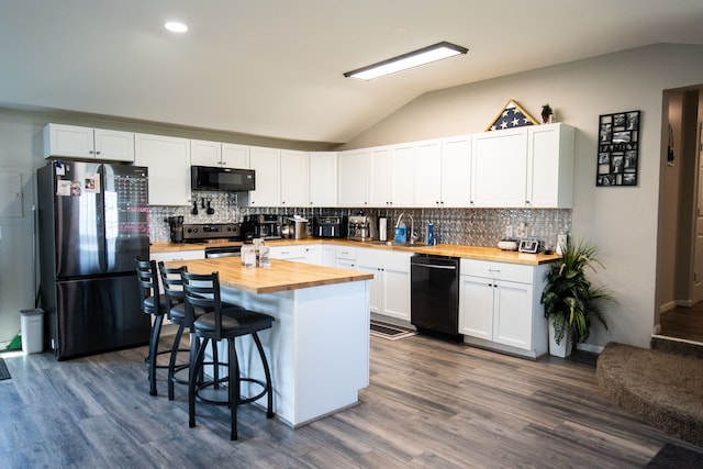 kitchen featuring black appliances, white cabinets, sink, vaulted ceiling, and butcher block countertops