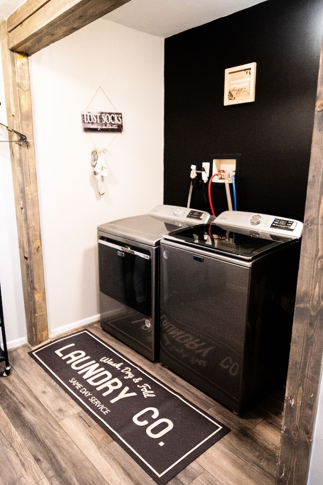 laundry area with washer and clothes dryer and wood-type flooring