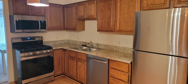 kitchen with light stone counters, appliances with stainless steel finishes, and sink