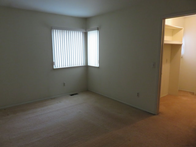 spare room featuring light colored carpet