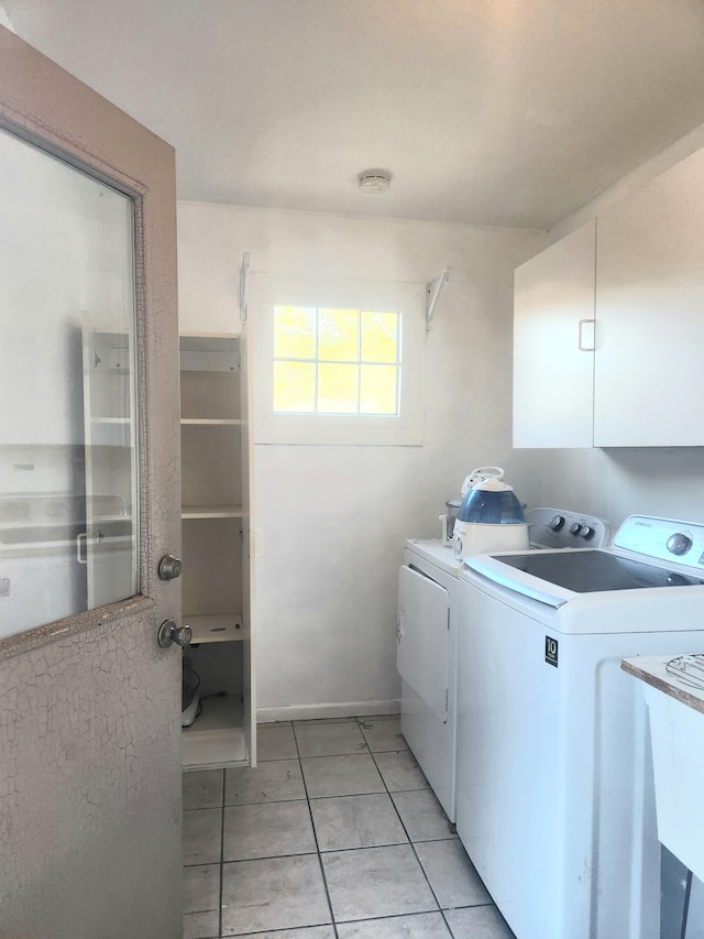 laundry area with light tile patterned floors, cabinets, and independent washer and dryer