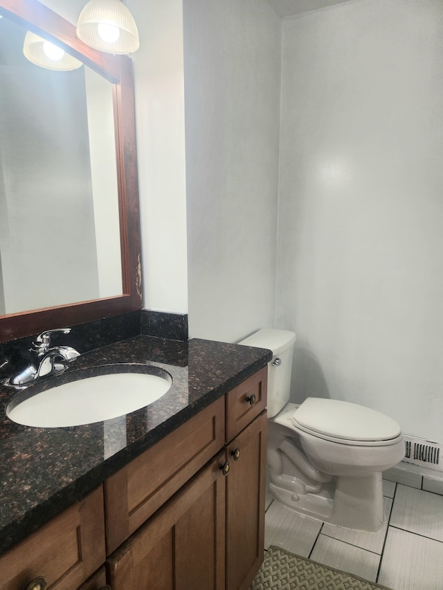 bathroom with tile patterned flooring, vanity, and toilet