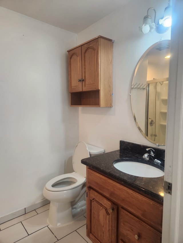 bathroom with tile patterned flooring, vanity, toilet, and a shower with door