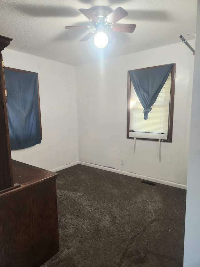 unfurnished room with ceiling fan, carpet, and a textured ceiling