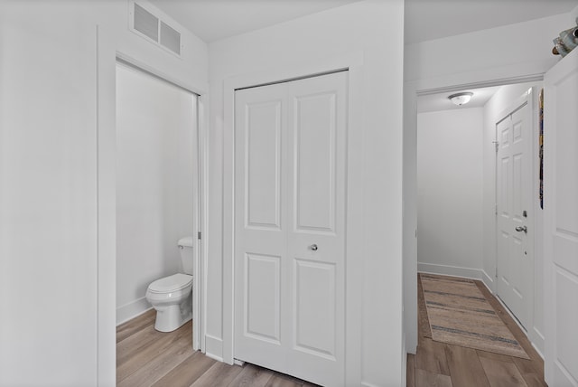 bathroom featuring wood-type flooring and toilet