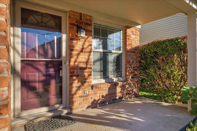 view of exterior entry featuring covered porch