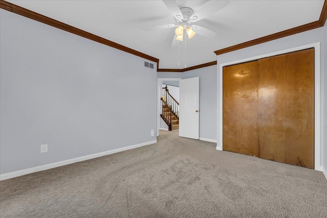 unfurnished bedroom with carpet flooring, a closet, ceiling fan, and crown molding