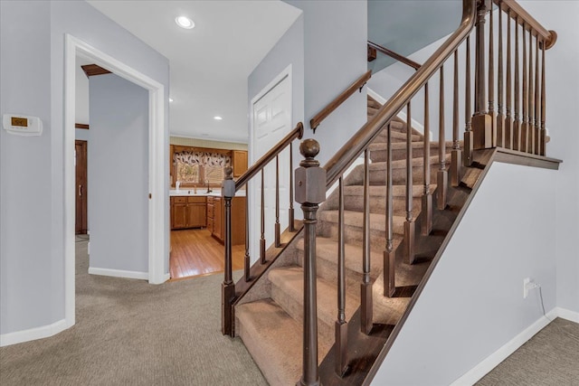 stairway with carpet floors and sink