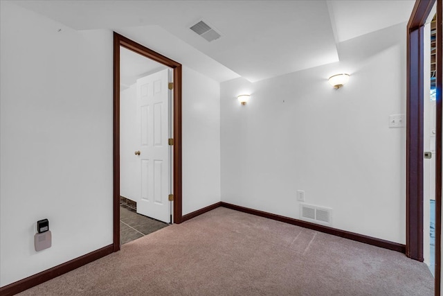 spare room featuring dark colored carpet