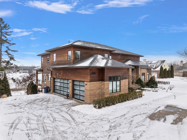 snow covered property featuring a garage