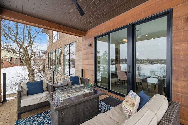 snow covered patio with outdoor lounge area and a ceiling fan