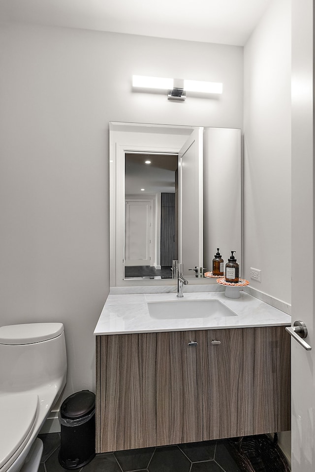 bathroom with tile patterned flooring, vanity, and toilet