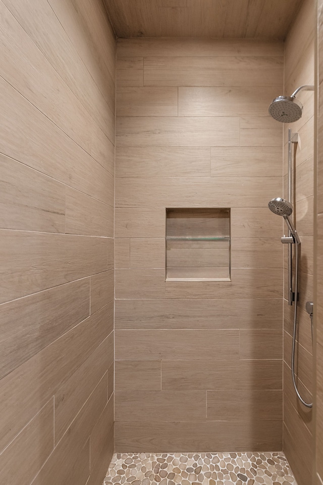 bathroom with tiled shower and wooden ceiling