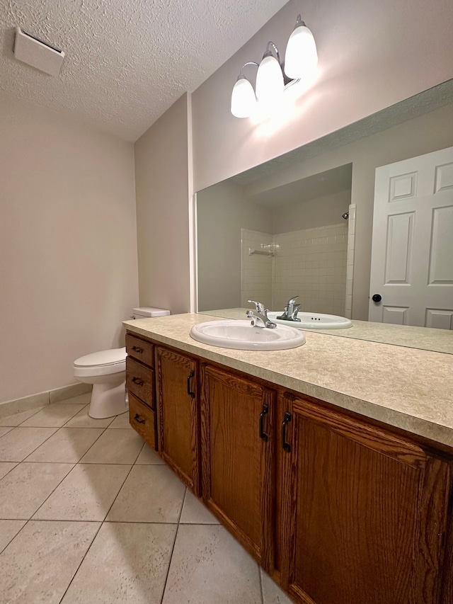 bathroom with tile patterned flooring, a shower, a textured ceiling, toilet, and vanity