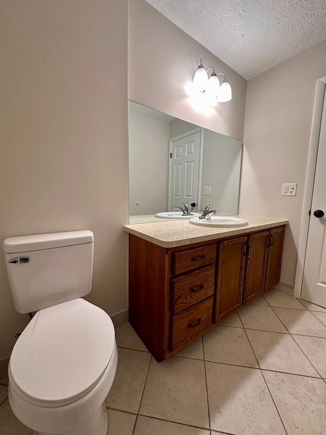 bathroom featuring tile patterned flooring, vanity, a textured ceiling, and toilet