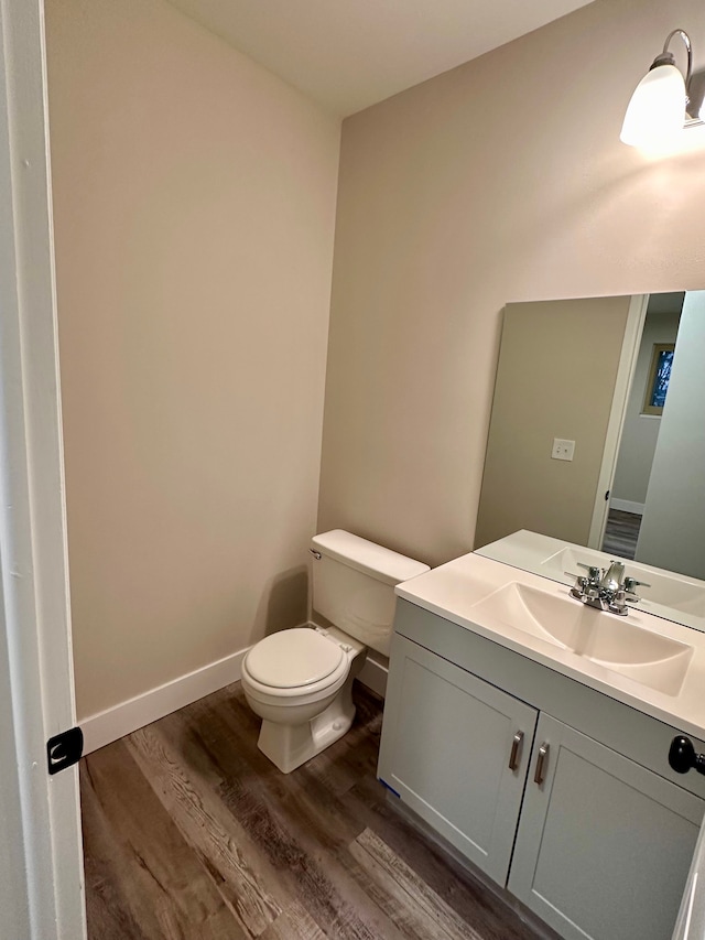 bathroom featuring wood-type flooring, vanity, and toilet