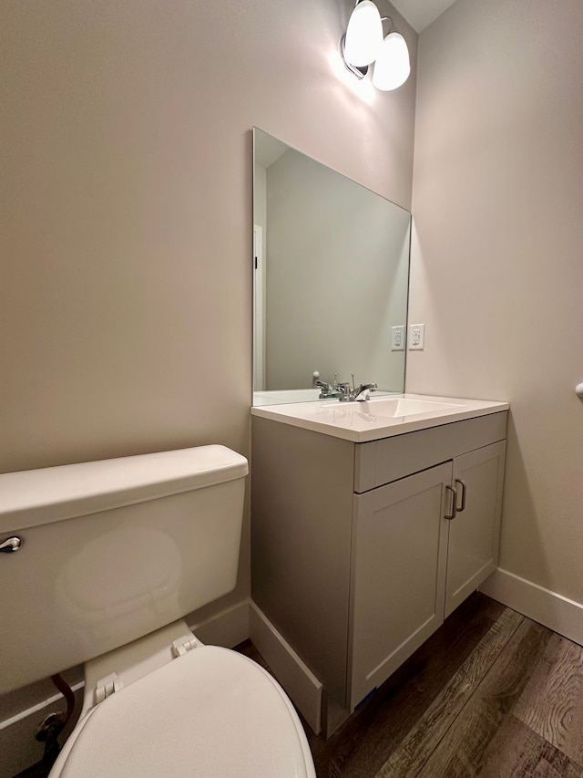 bathroom with hardwood / wood-style floors, vanity, and toilet