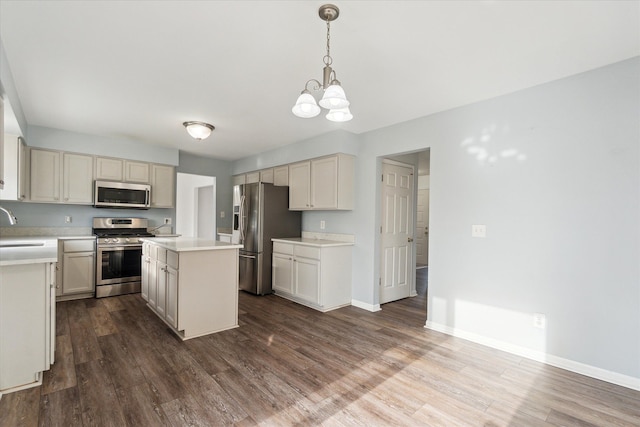 kitchen featuring sink, a center island, dark hardwood / wood-style flooring, pendant lighting, and appliances with stainless steel finishes