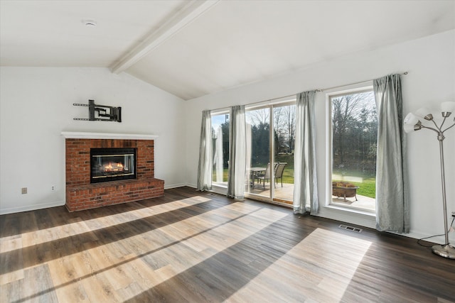 living room featuring a fireplace, vaulted ceiling with beams, hardwood / wood-style flooring, and a healthy amount of sunlight