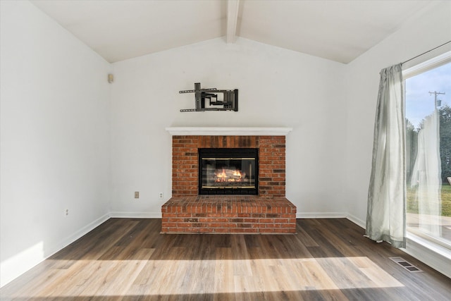 unfurnished living room with a fireplace, hardwood / wood-style floors, and lofted ceiling with beams