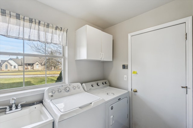 laundry area with separate washer and dryer, sink, and cabinets