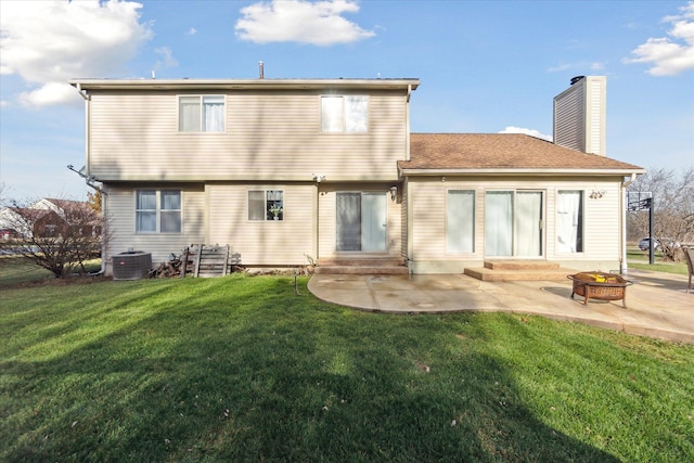 rear view of property with a yard, a patio, and a fire pit